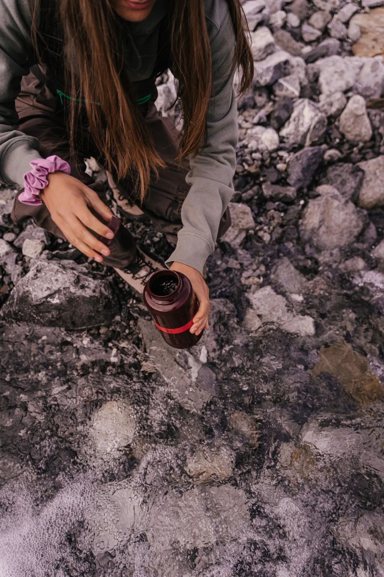 Amelia Grose, a graduate student at Michigan State University, collects a water sample in Trevor Creek in the Brooks Range, Credit: Jansen Nipko
