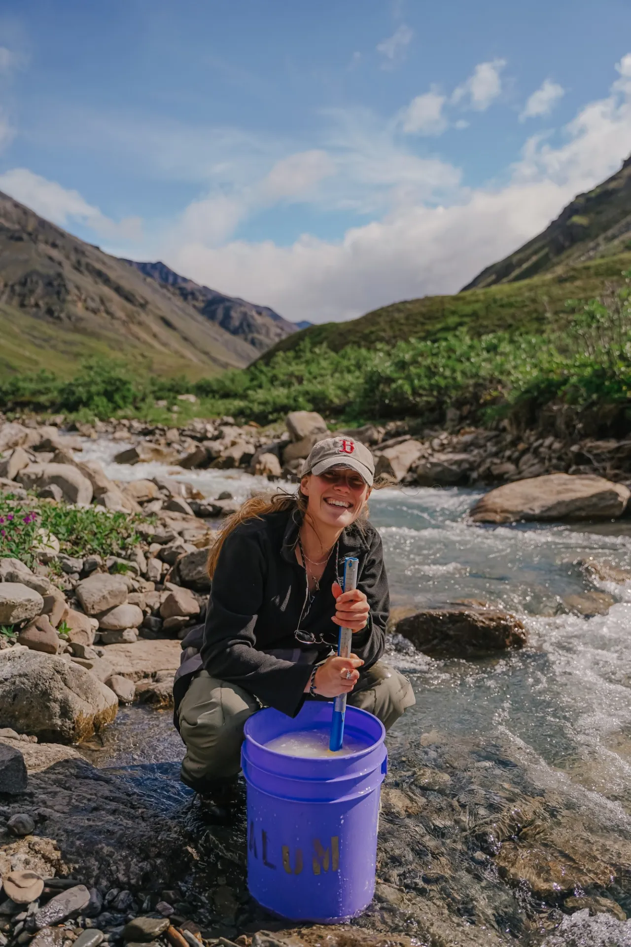 Graduate student Abby Rec, from University of Vermont, smiles as she stirs a salt slug mixture near Trevor Creek in the Brooks Range, Credit: Jansen Nipko